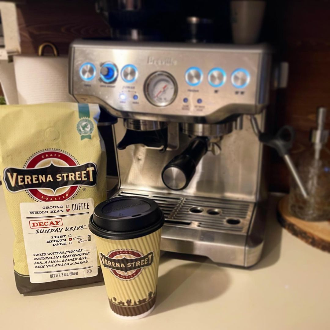 Decaf espresso beans in front of a espresso machine
